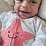 baby, infant, smile, happy, onesie, starfish, shell_pattern, hand, blanket, cozy, cute, face, child, soft_texture, sleepwear, lying_down, closeup, indoors, comfort, adorable