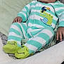 Nahzir joined the competition — help win amazing prizes! baby, child, onesie, striped_clothing, crocodile_slippers, infant, baby_seat, blanket, cushion, indoor, carpet, person, footwear, cute, relaxed, soft_lighting, green, white, seated, young_child