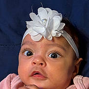 Milla joined the competition — help win amazing prizes! baby, infant, face, headband, flower, pink_clothing, hands, wide_eyes, curious, portrait, closeup, soft_skin, cute, child, young, adorable, indoors, expression, headwear, person