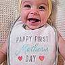 baby, smiling, headband, bib, text, blanket, happy, infant, portrait, cute, child, clothing, fabric, face, human, screenshot, social_media, indoors, celebration, mother's_day