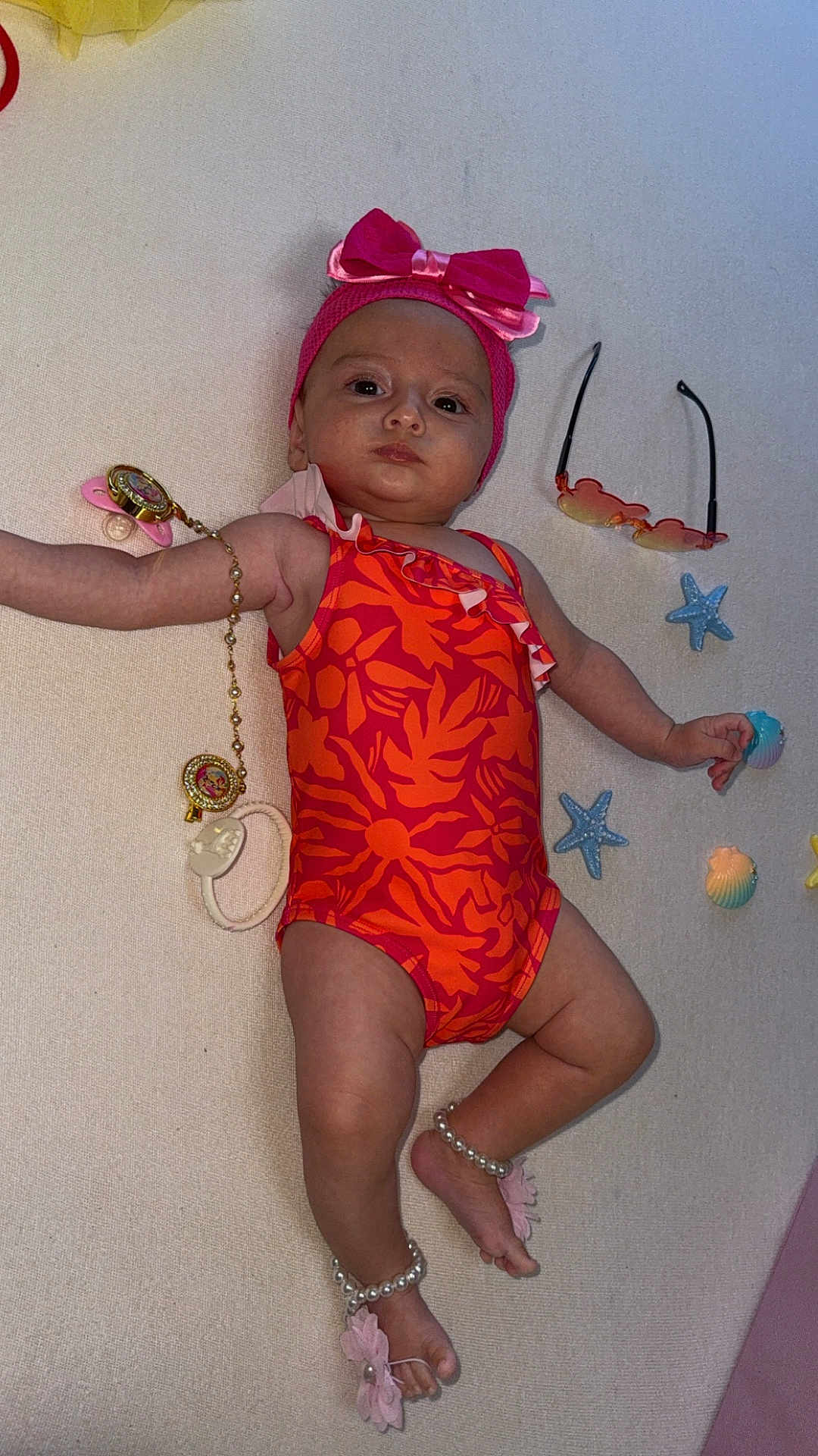 Chloë a rejoint le concours — aidez-le/la à gagner de superbes lots ! baby, infant, swimsuit, headband, bow, anklets, pearls, flower, sunglasses, starfish, seashells, lying_down, child, accessories, pink, orange, indoor, portrait, cute, playful