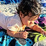 Javier is registered to the contest to win money with this photo: baby, child, beach, towel, sand, sunlight, curly_hair, outdoor, daylight, focus, relaxation, vacation, summer, skin, infant, clothing, colorful, background, portrait, closeup