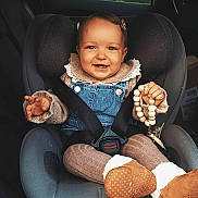 Giulia participe au concours pour gagner de l'argent avec cette photo : toddler, child, car_seat, smiling, denim_overall, beaded_toy, car_interior, seatbelt, warm_clothing, boots, hair_clip, happy, sitting, baby, window, greenery, vehicle, portrait, cute, indoor