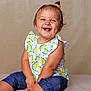 baby, background, barefoot, blue_jeans, cheerful, child, clothing, cute, expression, eyes, face, happy, infant, lemon_pattern, ponytail, portrait, sitting, skin, smiling, studio