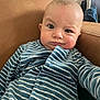 baby, infant, child, striped_clothing, blue_clothing, onesie, face, expression, chair, indoor, furniture, person, cute, portrait, skin, head, eyes, mouth, sitting, casual