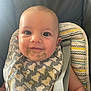 Louis a rejoint le concours — aidez-le/la à gagner de superbes lots ! baby, bib, messy, food, high_chair, smiling, face, child, infant, feeding, cute, straps, clothing, seat, happy, portrait, expression, indoor, young, person