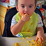 toddler, child, high_chair, food, macaroni_and_cheese, messy, bib, kitchen, eating, cheese, tray, young_child, person, indoor, meal, hand, face, clothing, short_hair, table