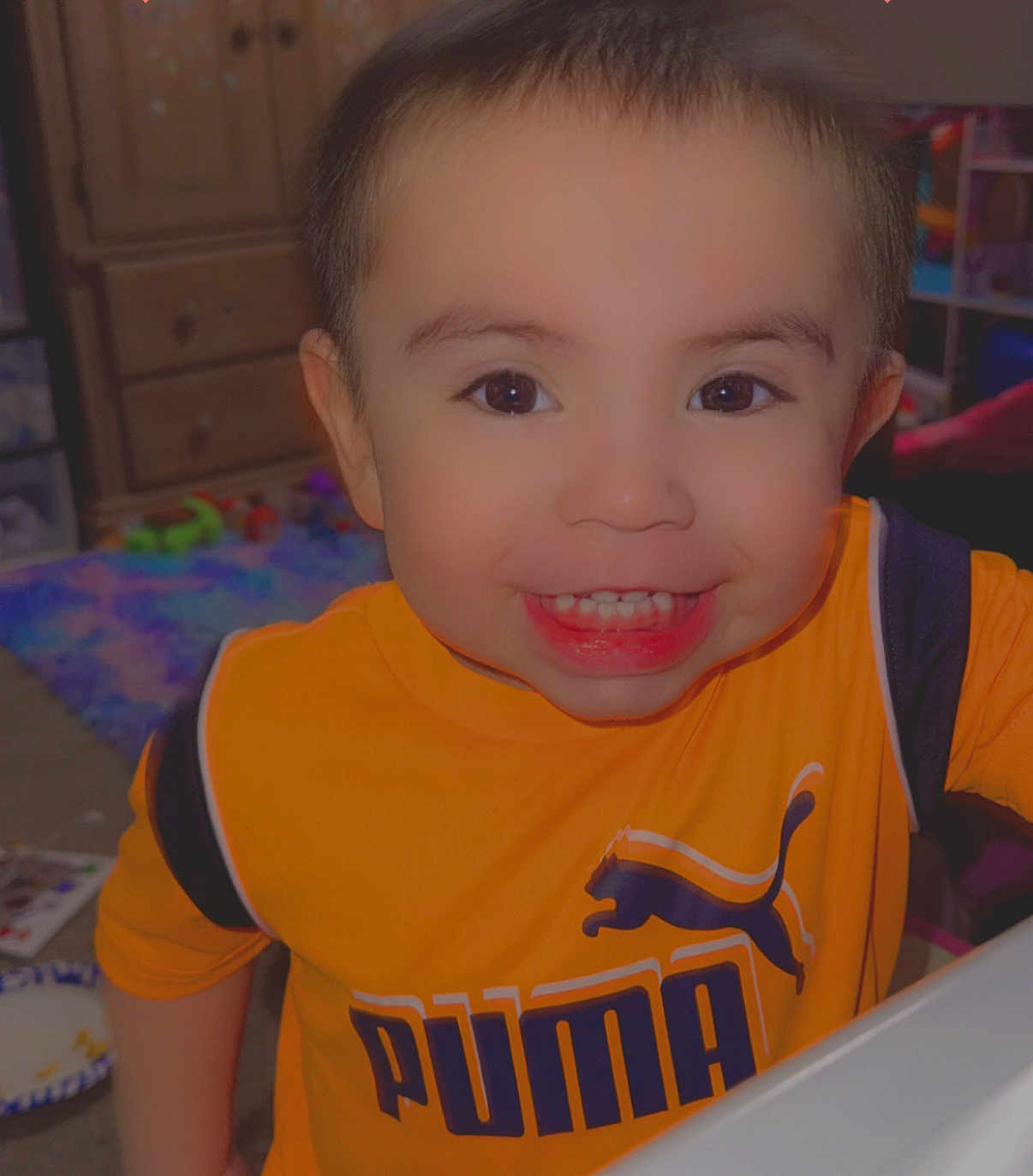 Anthony joined the competition — help win amazing prizes! child, toddler, smile, face, indoor, clothing, orange_shirt, puma_logo, toy, playroom, furniture, drawer, happy, person, photography, short_hair, eyes, expression, cheerful, young