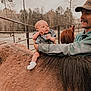 animal, baby, cap, clothing, face, happy, hat, head, horse, hosiery, laughing, nature, outdoors, pants, people, person, photography, portrait, smile, sock