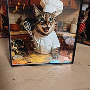 Bonnie is registered to the contest to win money with this photo: baking, bandana, cat, chef_hat, closeup, cupcake_liners, decor, framed_photo, green_eyes, kitchen_background, muffin_tin, photobomb, picture_frame, portrait, reflection, tabby_cat, tabletop, whisk, whiskers, wood_surface