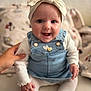 baby, smiling, headband, bow, denim_overalls, white_shirt, tights, white_shoes, hand, indoor, cozy, person, child, cute, happy, sitting, face, portrait, infant, support
