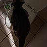 cat, toilet, bathroom, tile_floor, trash_bin, indoor, pet, curious, animal, dark, shadow, floor, tail, white, door, plastic, container, quiet, investigation, low_light