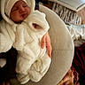 baby, newborn, sleeping, white_onesie, hat, cushion, hand, blanket, indoor, soft_texture, cozy, infant, person, skin, furniture, warm_lighting, rest, child, clothing, cute