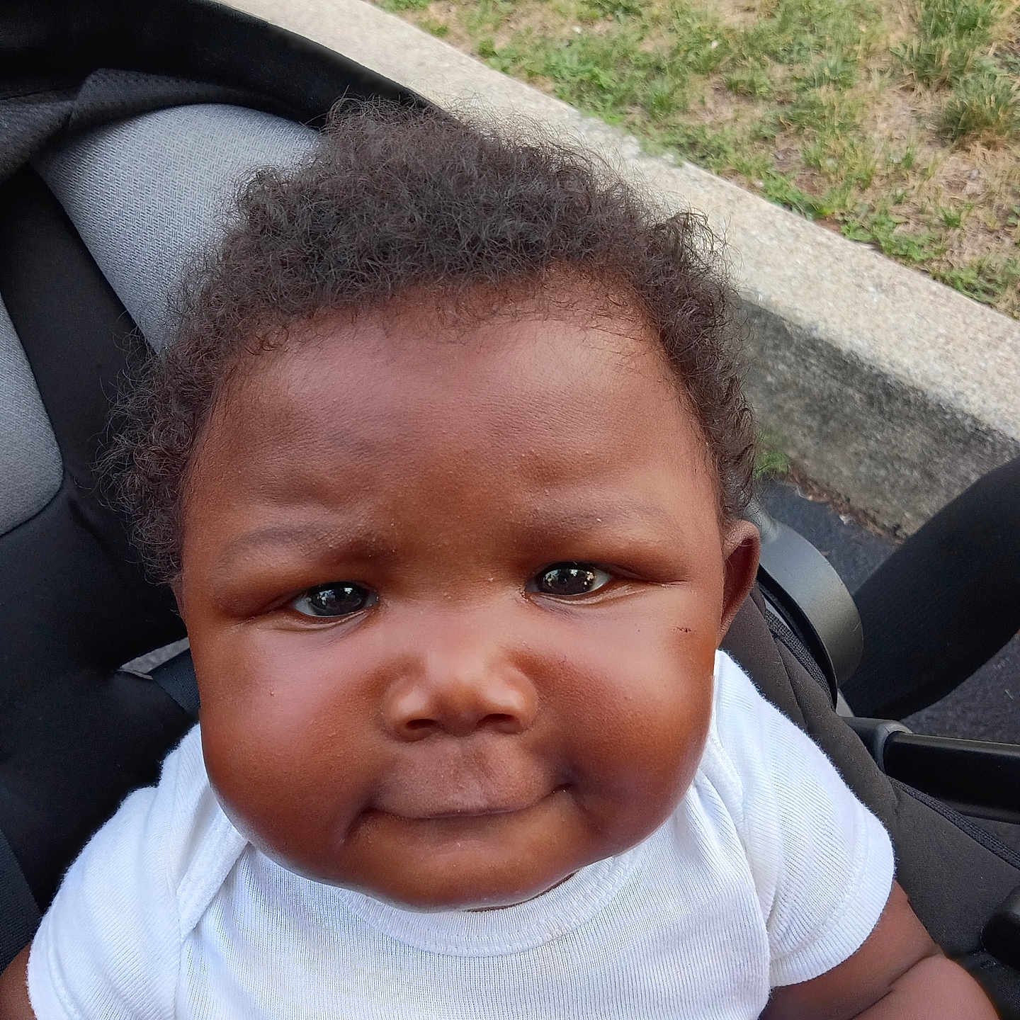 Lacoya joined the competition — help win amazing prizes! baby, child, closeup, curb, cute, expression, face, grass, hair, head, infant, outdoor, person, portrait, seat, sitting, skin, stroller, white_shirt, young_child