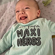 Charly participe au concours pour gagner de l'argent avec cette photo : baby, infant, smiling, onesie, pacifier, bed, blanket, face, mouth_open, tongue, happy, portrait, close_up, fabric, text_on_clothing, pattern, head, skin, nursery_bedding, pastel_color