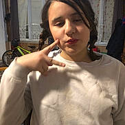 Chloe participe au concours pour gagner de l'argent avec cette photo : child, girl, braids, white_sweater, peace_sign, indoor, bicycle, window, curtain, wooden_wall, casual, pose, expression, face, person, young, room, furniture, lighting, candid