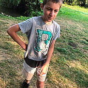 Lucas participe au concours pour gagner de l'argent avec cette photo : boy, child, outdoor, grass, trees, tshirt, shorts, casual_clothing, standing, nature, young, person, daylight, forest, footwear, black_shoes, greenery, summer, candid, portrait