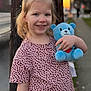 Ava joined the competition — help win amazing prizes! child, girl, smile, teddy_bear, plush_toy, sunset, outdoor, sidewalk, telephone_pole, portrait, blonde_hair, patterned_dress, holding, happy, dimples, casual_clothing, bokeh, candid, walking_path, playful