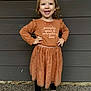 Ava is registered to the contest to win money with this photo: casual, child, confident, cute, dress, fall_theme, fashion, footwear, girl, hands_on_hips, happy, leggings, outdoor, portrait, pumpkin_spice, shoes, smile, standing, wooden_wall, young_child