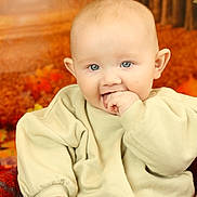 Finley joined the competition — help win amazing prizes! autumn, baby, background, beige_clothing, blue_eyes, child, cozy, cute, face, fall_leaves, hand, indoor, infant, orange, portrait, sitting, smiling, soft_texture, sweater, warm_colors