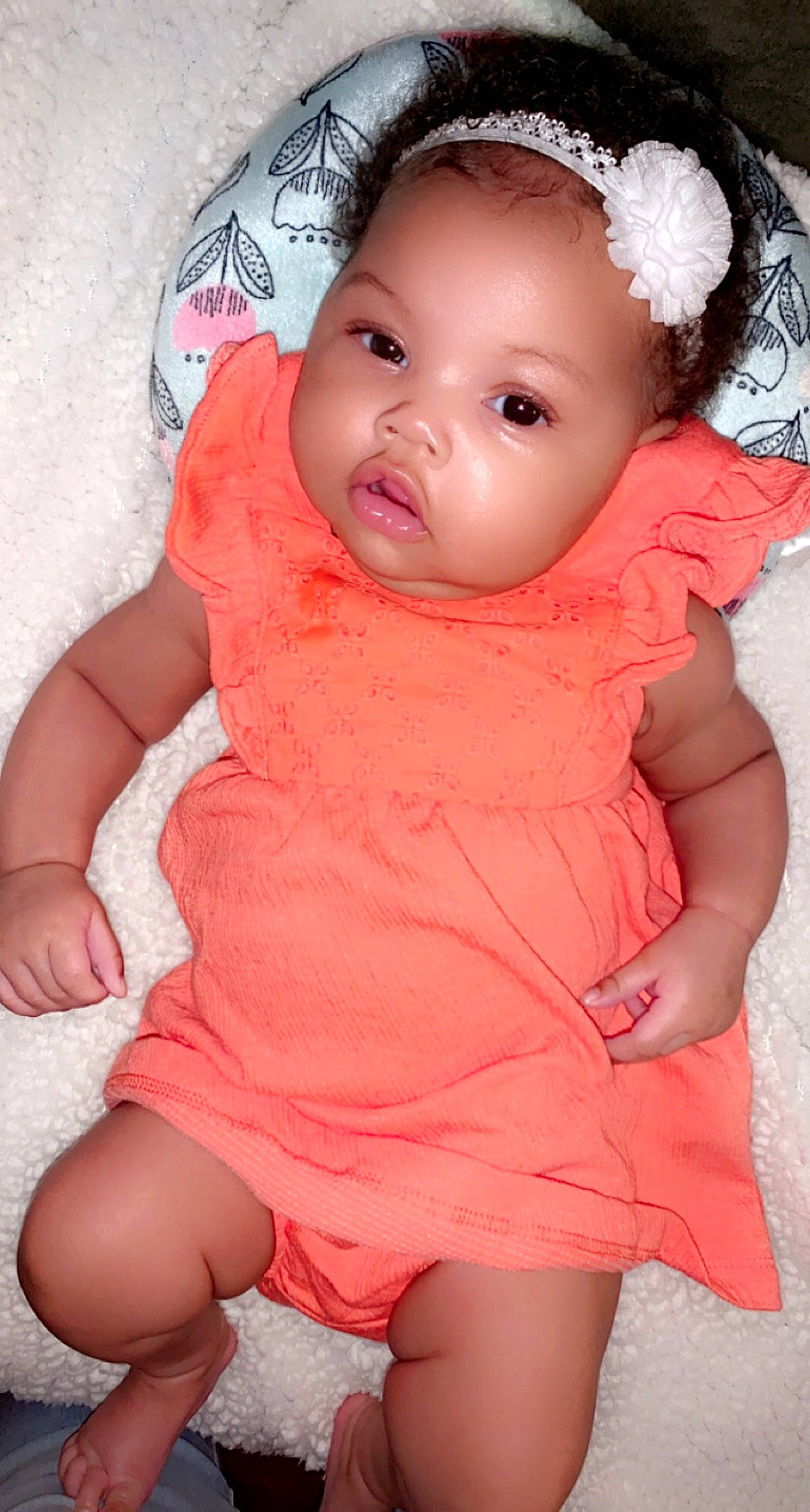 Naomi Reign is registered to the contest to win money with this photo: baby, baby_toddler_clothing, cheek, dress, eye, eyebrow, face, hand, head, human_body, iris, lip, mouth, neck, orange, organ, person, pink, skin, sleeve