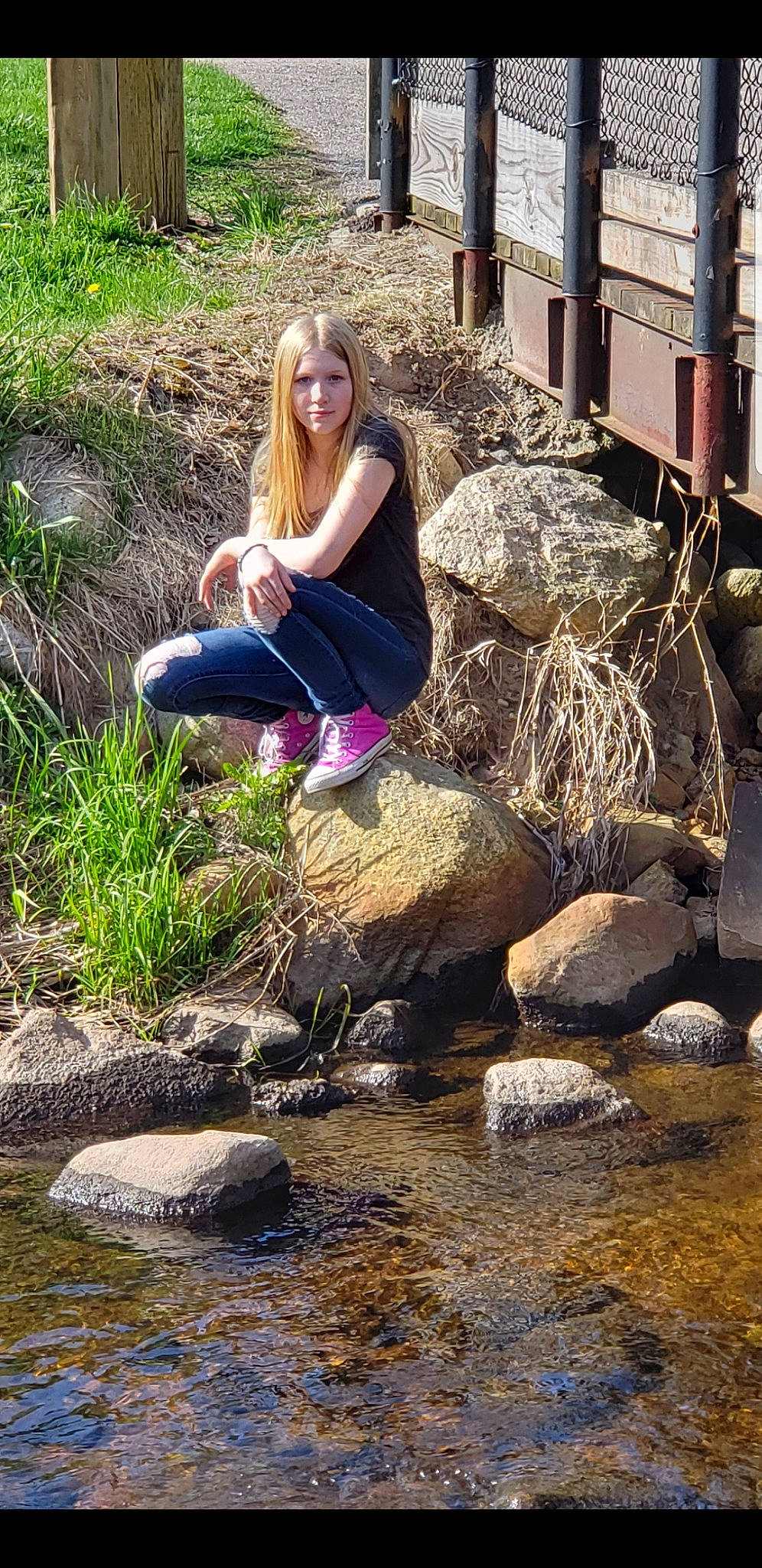 Greenlee is registered to the contest to win money with this photo: bank, fawn, grass, leisure, long_hair, person, plant, rock, sitting, stream, tree, water, watercourse