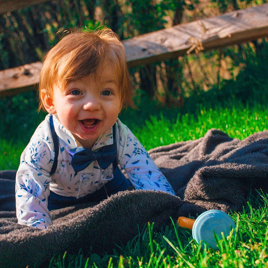 Kyler joined the competition — help win amazing prizes! accessories, baby, backyard, blanket, clothing, face, formalwear, grass, head, lawn, nature, outdoors, pants, person, photography, plant, portrait, sitting, tie, yard