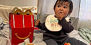 Maliyah is registered to the contest to win money with this photo: toddler, child, bed, happy_meal, fast_food, nuggets, fries, bib, snack, indoor, curtain, blanket, clothing, foot, eating, messy, face, person, toy, light