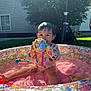 Maliyah is registered to the contest to win money with this photo: toddler, child, toy, pool, inflatable_pool, water, pink_water, flower_pattern, splash_pool, outdoor, grass, sunlight, wet_hair, playing, summer, backyard, colorful, cute, person, happy
