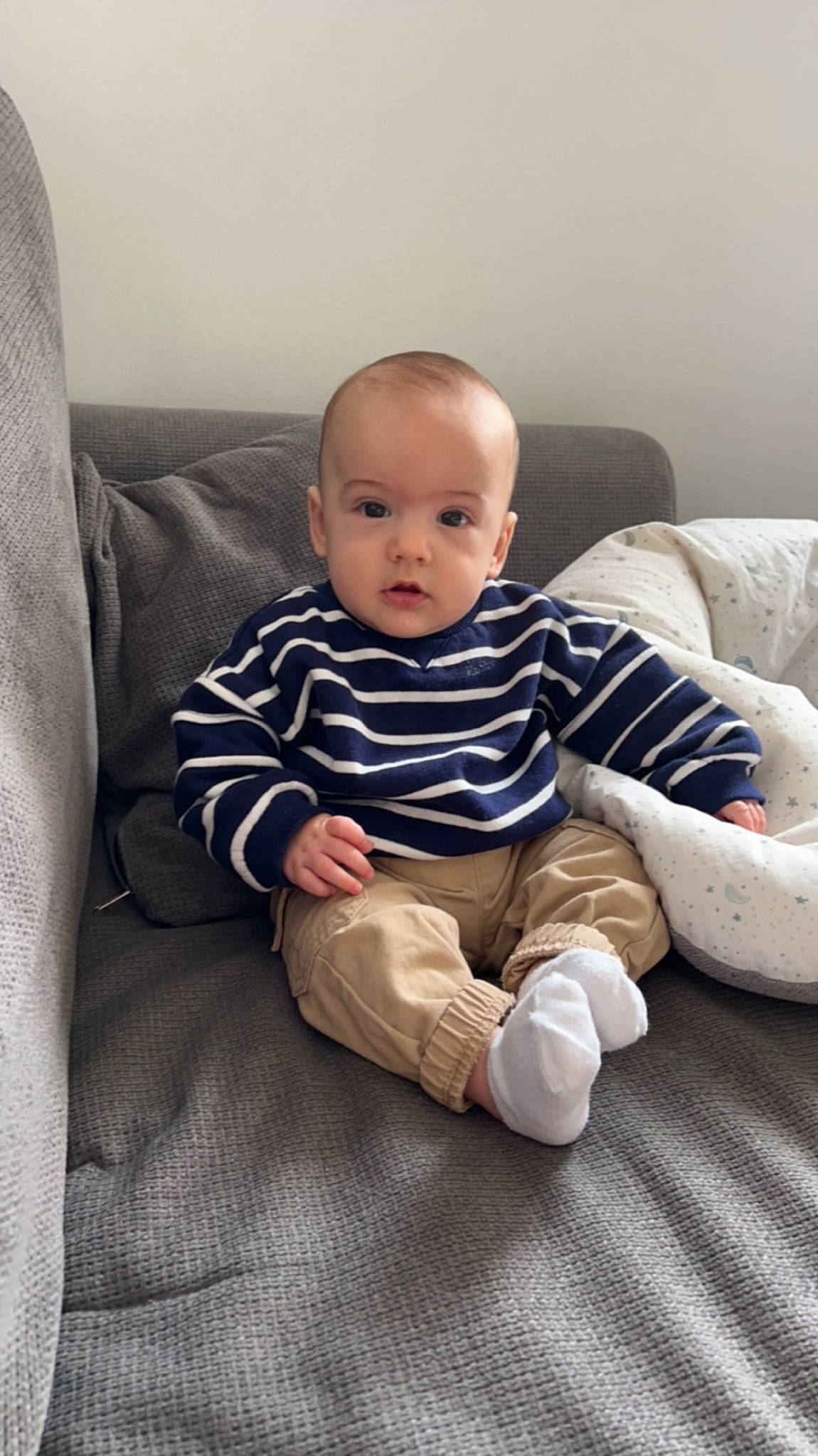 Rafaël a rejoint le concours — aidez-le/la à gagner de superbes lots ! baby, baby_toddler_clothing, cheek, child, comfort, couch, facial_expression, flash_photography, flooring, human_leg, knee, leg, linens, person, room, sitting, skin, sleeve, sock, standing