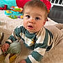 baby, child, toy, plush_toy, striped_sweater, rug, floor, indoors, curious, looking_up, hand, face, playtime, colorful, soft_toy, baby_gate, crawling, expression, young_child, casual_clothing