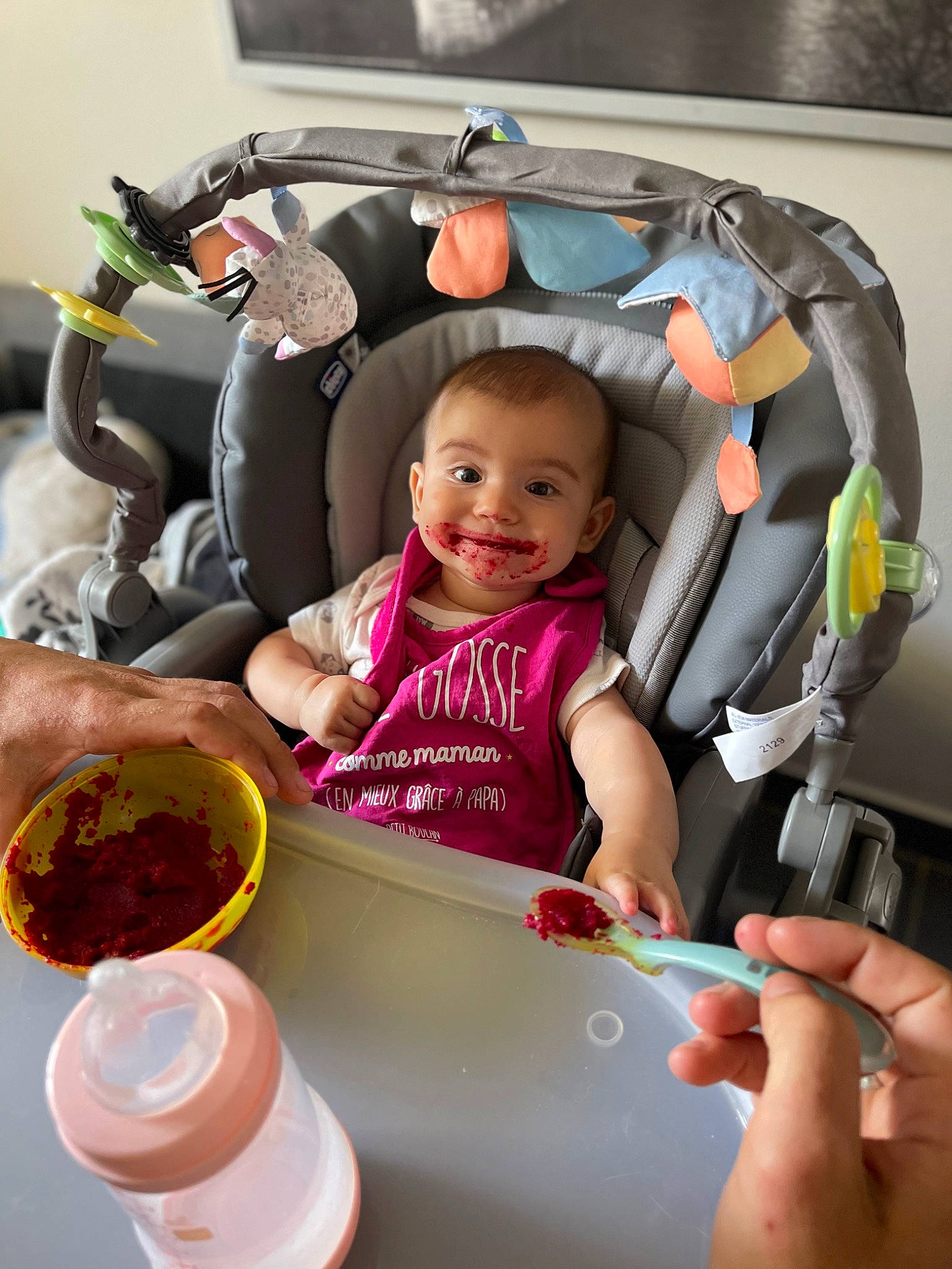 Lyna a rejoint le concours — aidez-le/la à gagner de superbes lots ! baby_carriage, baby_products, baby_toddler_clothing, child, comfort, cooking, cuisine, dish, dishware, fun, happy, joy, magenta, material_property, nail, person, product, smile, sweetness, t_shirt