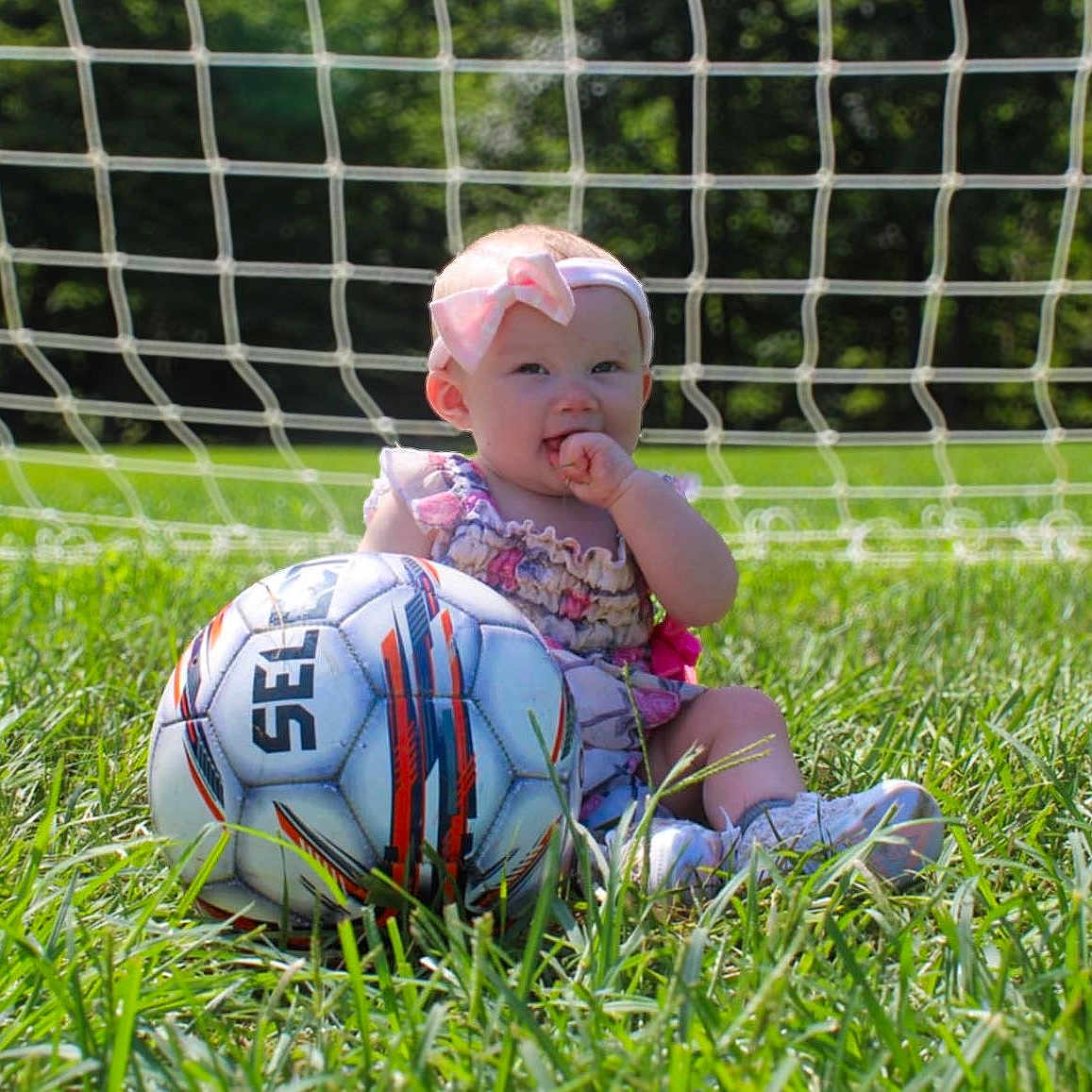 Opheila is registered to the contest to win money with this photo: baby, backyard, ball, face, field, football, grass, head, nature, outdoors, people, person, photography, plant, portrait, soccer, soccerball, sphere, sport, summer