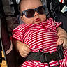 David joined the competition — help win amazing prizes! baby, child, sunglasses, stroller, red_striped_clothing, infant, seatbelt, cute, relaxed, portrait, summer, fashion, hand, face, head, indoor, person, expression, seat, casual