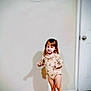 child, toddler, onesie, barefoot, standing, tile_floor, shadow, wall, indoor, door, television, candid, home, young_child, girl, light, floor, room, casual, patterned_clothing
