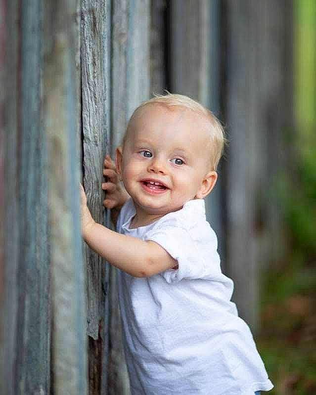 Tucker is registered to the contest to win money with this photo: baby, baby_toddler_clothing, blond, child, flash_photography, formal_wear, fun, grass, happy, joy, laugh, people_in_nature, person, portrait, portrait_photography, sitting, smile, toddler, tree, vacation