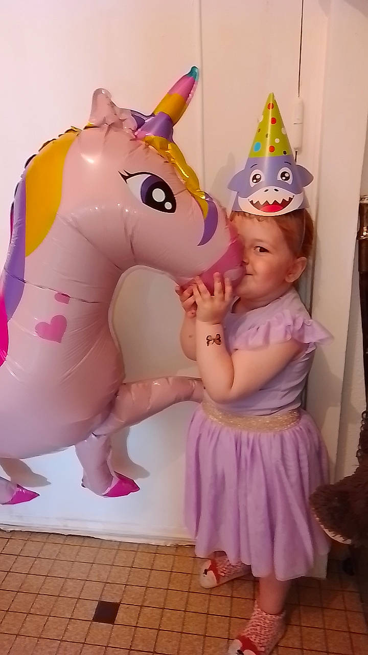 Camillia participe au concours pour gagner de l'argent avec cette photo : baby_toddler_clothing, child, costume_hat, event, fictional_character, fun, happy, horse, inflatable, magenta, mythical_creature, party_hat, party_supply, person, pink, purple, recreation, toddler, unicorn
