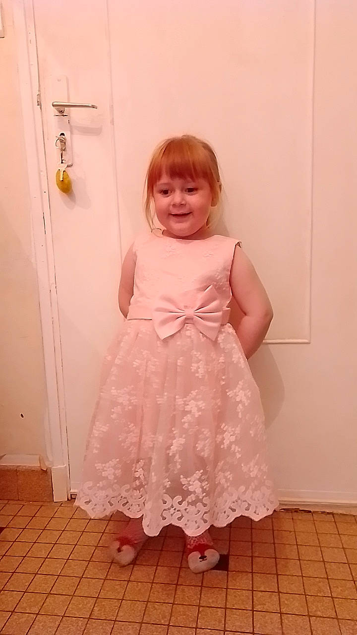 Camillia participe au concours pour gagner de l'argent avec cette photo : baby_toddler_clothing, day_dress, door, dress, embellishment, flooring, happy, hardwood, human_leg, joy, magenta, one_piece_garment, person, pink, shoulder, sleeve, smile, standing, toddler, waist