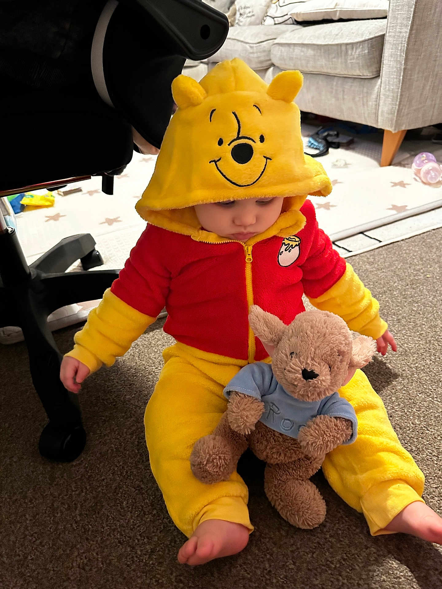 Margo joined the competition — help win amazing prizes! toddler, child, plush_toy, stuffed_animal, hoodie, winnie_the_pooh, yellow_clothing, red_clothing, carpet, indoor, furniture, sofa, baby_bottle, foot, sitting, cute, home, cozy, baby, childwear