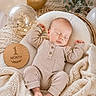 baby, sleeping, infant, blanket, balloon, wooden_milestone, pajamas, cozy, celebration, soft_texture, nursery, peaceful, cute, portrait, newborn, resting, decor, neutral_colors, baby_bedding, milestone_marker