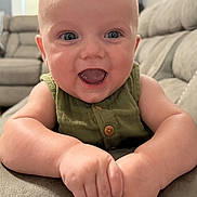 Waylon joined the competition — help win amazing prizes! baby, child, smiling, happy, infant, face, hands, green_clothing, indoor, living_room, couch, furniture, portrait, cute, skin, head, eyes, mouth, button, soft_surface