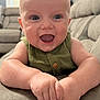 baby, child, smiling, happy, infant, face, hands, green_clothing, indoor, living_room, couch, furniture, portrait, cute, skin, head, eyes, mouth, button, soft_surface