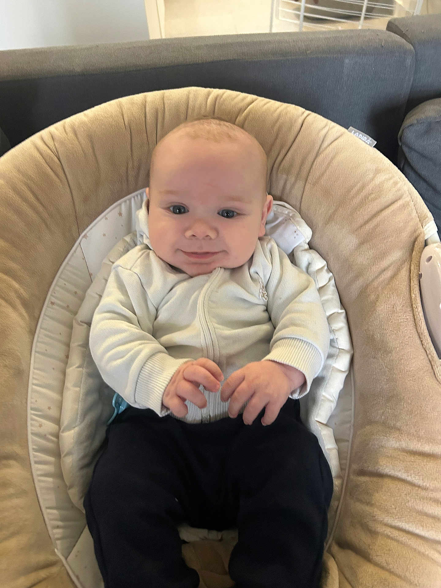 Mylann a rejoint le concours — aidez-le/la à gagner de superbes lots ! baby, infant, child, face, smile, clothing, jacket, pants, seat, cushion, furniture, indoor, person, cute, young, hands, head, eyes, happy, cozy