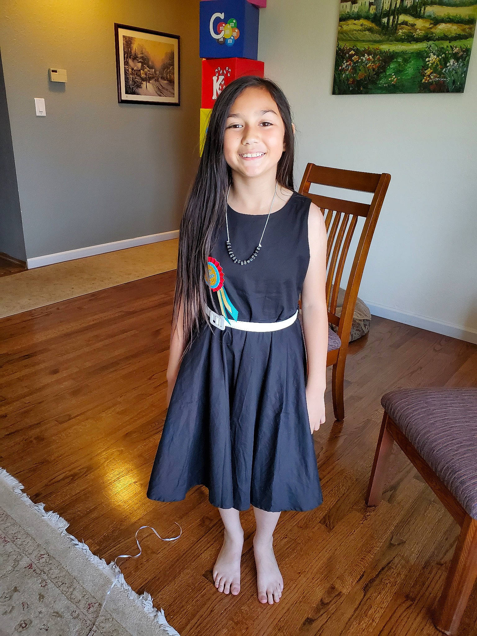 Alyssia joined the competition — help win amazing prizes! brown, child, clothing, dress, floor, flooring, hardwood, joy, person, room, shoe, shoulder, sitting, sleeve, standing, t_shirt, top, trunk, waist, wood