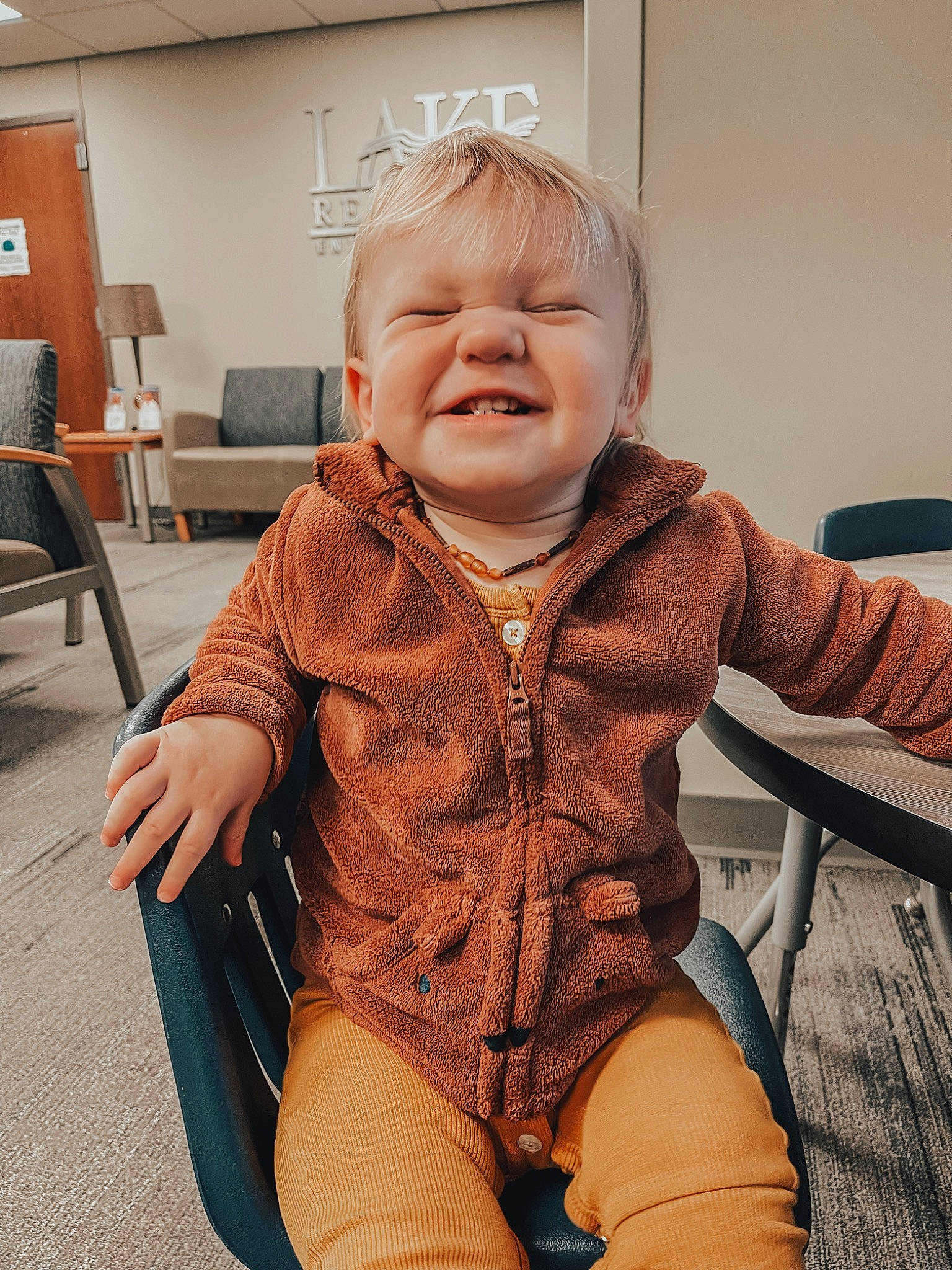 Weston is registered to the contest to win money with this photo: baby_toddler_clothing, chair, cheek, comfort, flooring, furniture, happy, head, headgear, iris, knee, leg, lip, mouth, neck, person, skin, sleeve, smile, thigh