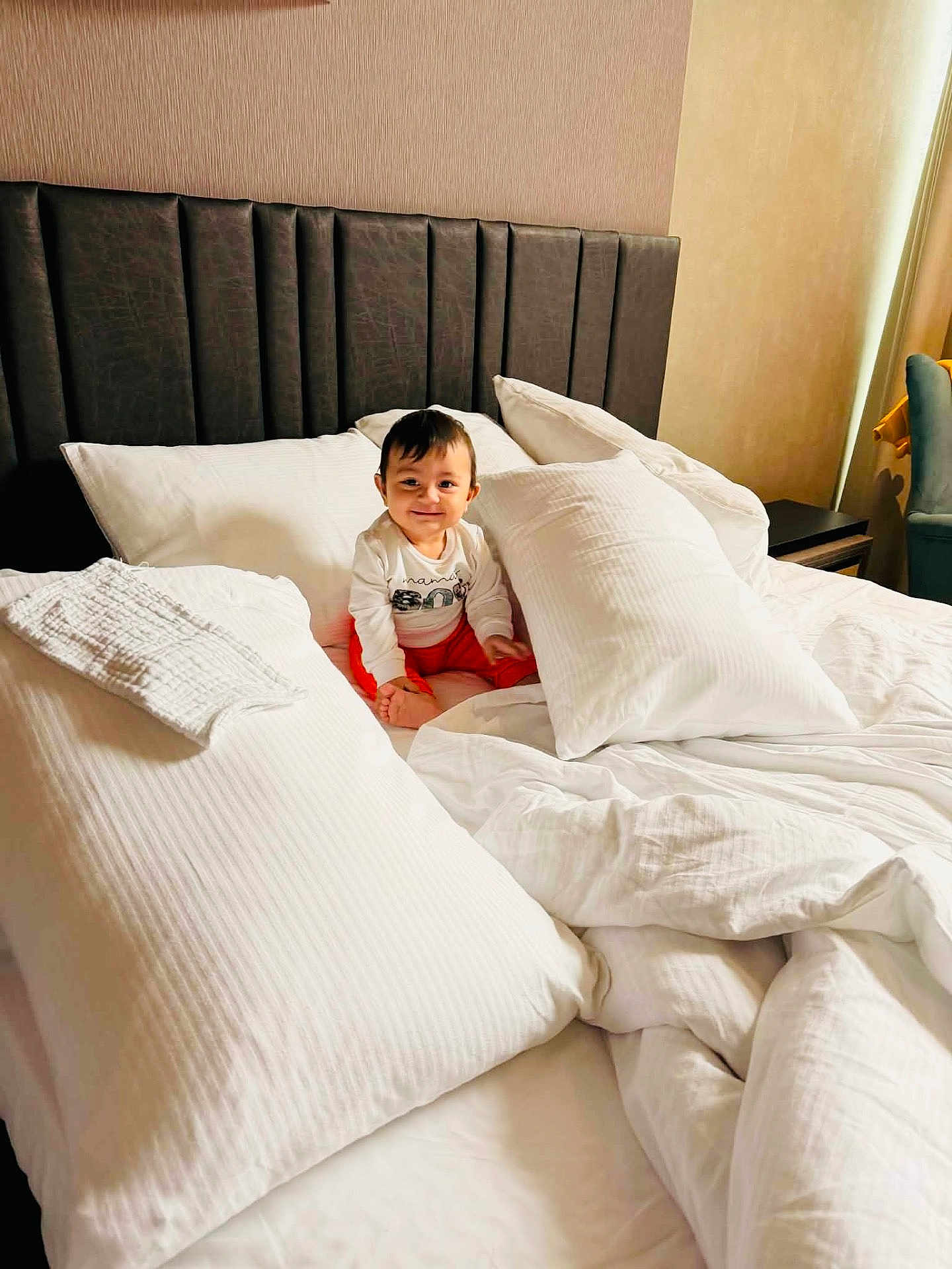 Adrian participe au concours pour gagner de l'argent avec cette photo : baby, bed, pillow, blanket, smile, child, indoors, furniture, cozy, white, comfort, headboard, clothing, room, sitting, happy, portrait, soft, home, sleep