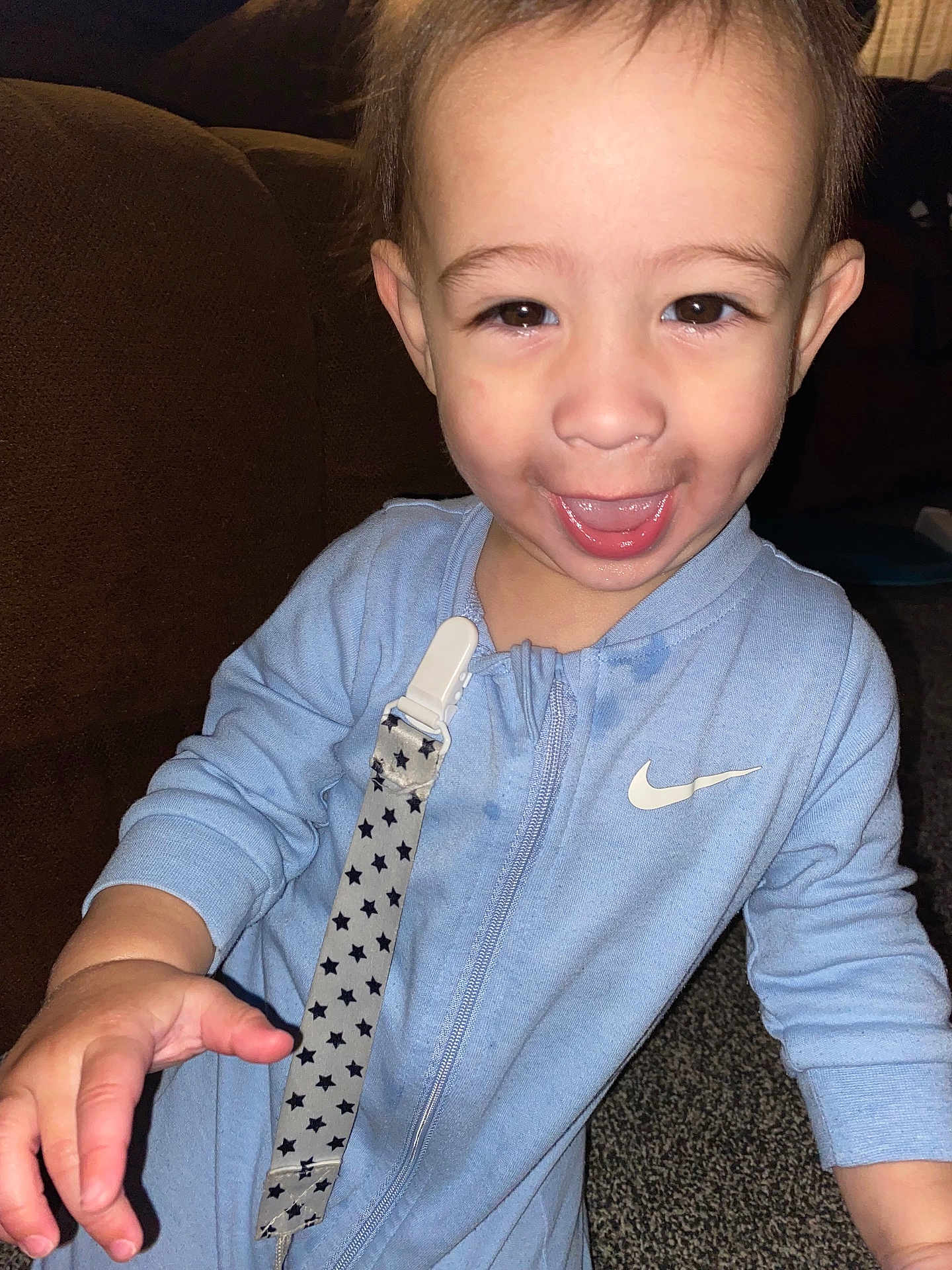 Grayson is registered to the contest to win money with this photo: toddler, child, smile, happy, onesie, clothing, indoor, carpet, couch, pacifier_clip, hand, face, person, baby, dimples, young_child, blue_clothing, zipper, fabric, cute