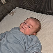 Kenny participe au concours pour gagner de l'argent avec cette photo : baby, infant, child, playpen, onesie, blanket, bedding, portrait, smile, hand, arm, face, cheeks, nursery, indoor, pajamas, lying_down, cute, soft_toys, relaxed