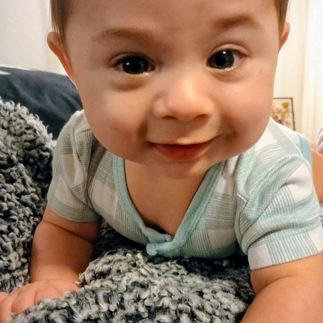 Micah joined the competition — help win amazing prizes! baby, blanket, child, closeup, cozy, crawling, curious, cute, expression, face, hands, happy, indoor, infant, light, onesie, portrait, smiling, soft_texture, young