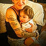 adult, baby, tattoo, hug, couch, home, people, smile, jeans, sitting, casual, indoor, comfort, child, affection, person, portrait, warmth, love, family